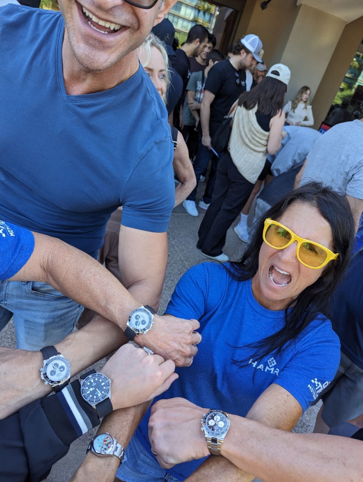 A group holding their wrists together to show off their watches at Tires & Timepieces