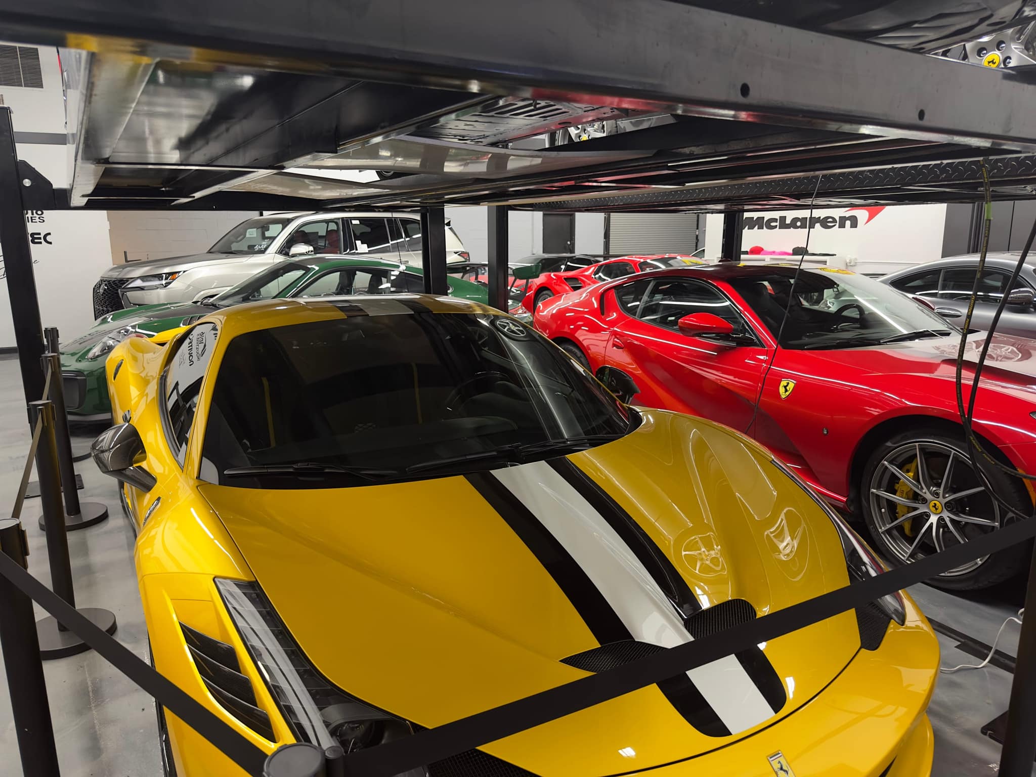 Cars raised on two-level lifts on a reconditioning floor