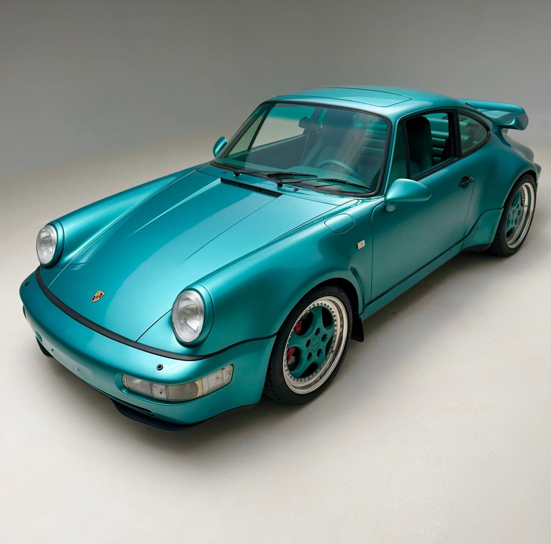 A teal Porsche 964 Turbo in a studio, sourced through the PaddockGavin network