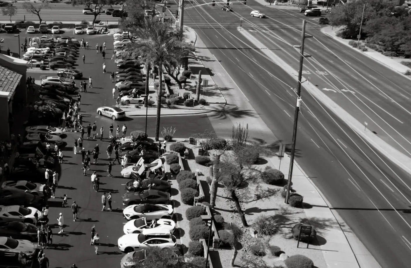 The October 2023 Tires and Timepieces edition from above: cars parked along both sides of the street and guests walking the row