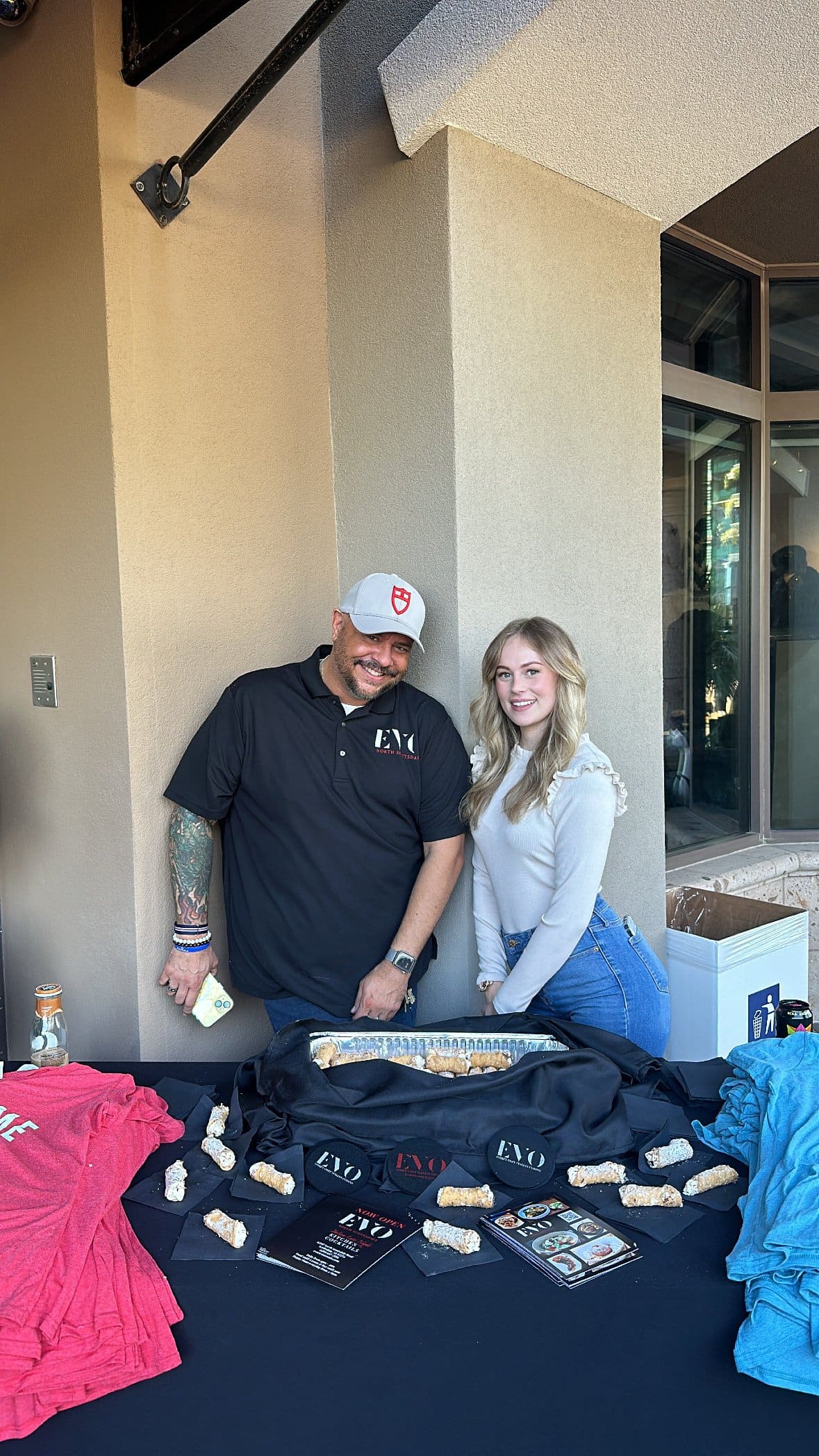 A vendor table for EVO North Scottsdale, with staff and cannoli for guests