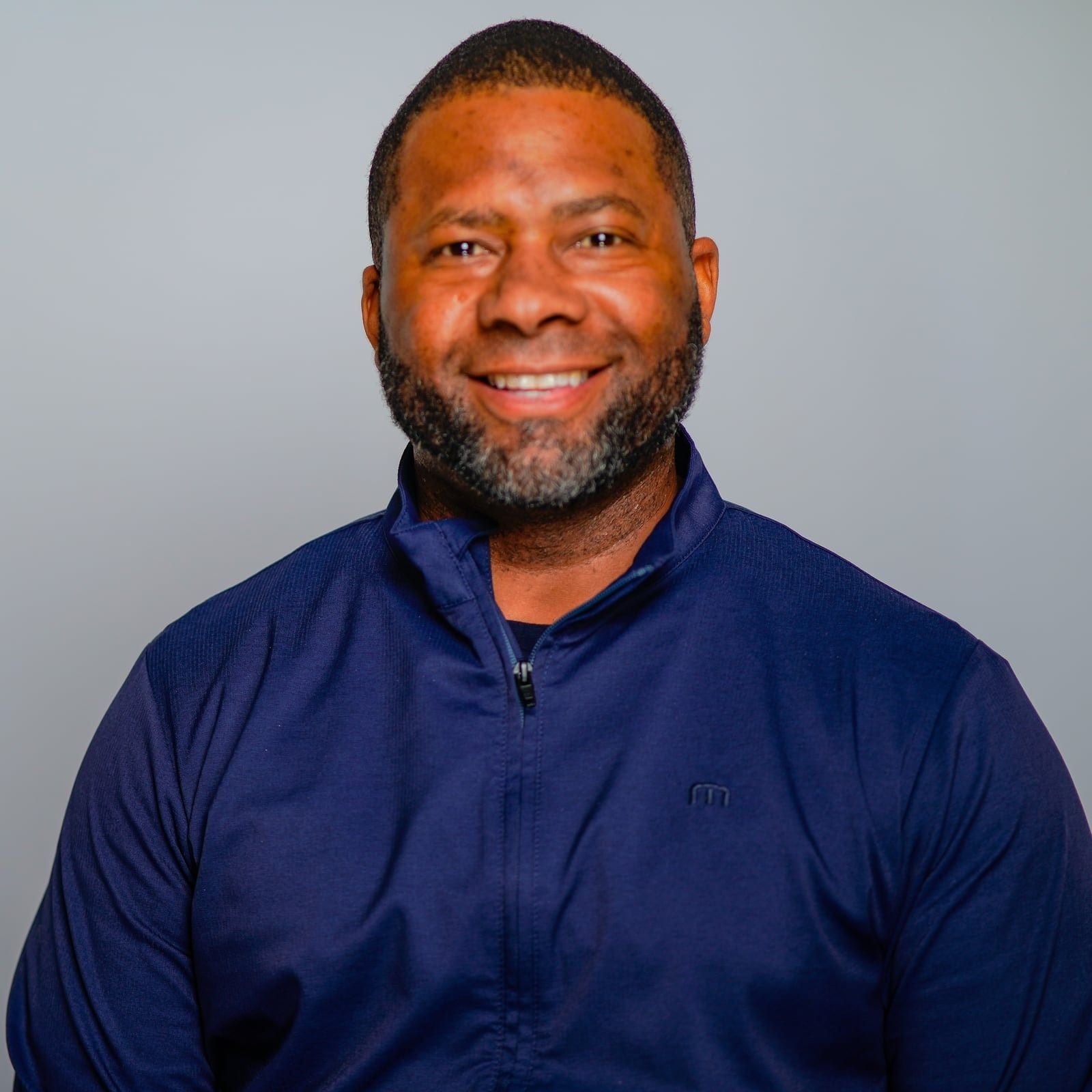 Gavin Brooks in a navy quarter-zip, smiling at the camera